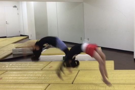 マットの上でバク転をする練習のようす（動きでぶれている写真）